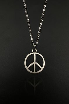 Step into a world of tranquility and serenity with our Peace Sign Necklace. This beautifully handcrafted necklace is perfect for both men and women, embodying the universal symbol of peace in a stylish and elegant manner. Whether you're a lover of all things boho or a dedicated follower of the hippie culture, our Peace Symbol Necklace is designed to resonate with your unique spirit and style. Embrace peace, radiate love, and express your unique style with our Peace Sign Necklace. This isn't just Bohemian Peace Sign Necklace For Gift, Silver Peace Sign Jewelry Gift, Symbolic Round Peace Sign Jewelry, Symbolic Silver Jewelry With Peace Sign, Symbolic Handmade Everyday Necklace, Everyday Symbolic Handmade Necklace, Vintage Jewelry With Peace Sign As Gift, Vintage Jewelry With Peace Sign For Gift, Vintage Peace Sign Jewelry Gift