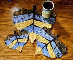 a cup of coffee sitting on top of a wooden table next to two pieces of paper