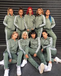 a group of women in matching tracksuits posing for a photo