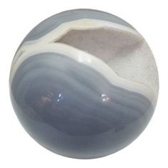 a gray and white marble ball sitting on top of a table