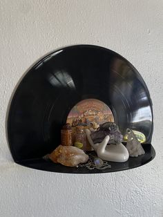 there is a black record shelf with various items on it