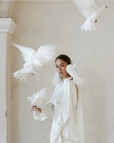 a woman standing in front of two white doves