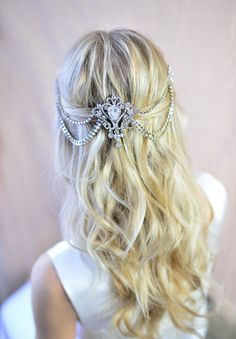 the back of a woman's head with long blonde hair and a crystal brooch