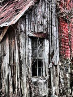 an old wooden building with vines growing around it