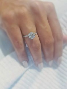 a woman's hand with a diamond ring on it