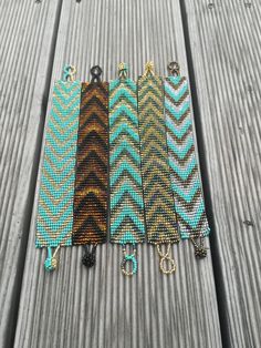 five different colors of beaded bracelets on top of a wooden table next to each other