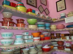 the shelves are filled with many different colored bowls and dishes on them, all stacked together