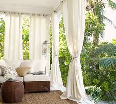 a living room with white drapes on the windows