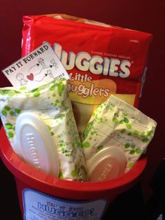 a red bucket filled with diapers and baby wipes