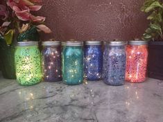 five jars with different colored glitters on them