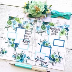 a planner with flowers on it next to a pen