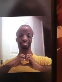 a man is smiling and holding his hands together in front of him while taking a selfie