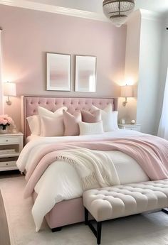 a bedroom with pink walls, white bedding and an upholstered headboard