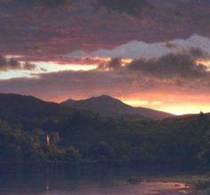 a painting of a lake with mountains in the background and clouds above it at sunset