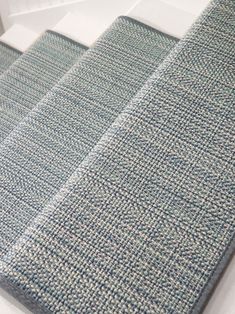 a close up view of a blue and white rug on top of a bed in a room