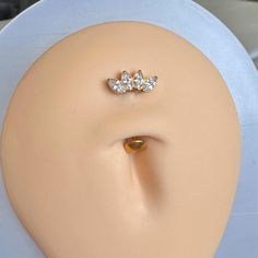 a white mannequin head with two gold nose rings on it's side