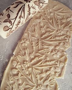 two pieces of carved clay sitting on top of a cement floor next to each other