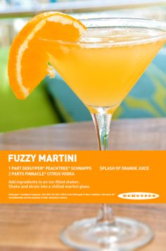 an orange martini sits on a table with the name fuzzy martini written in spanish and placed next to it