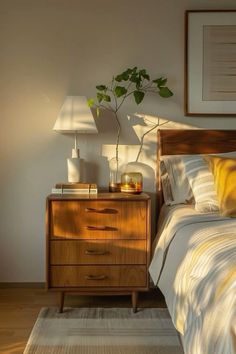 a bed room with a neatly made bed and a plant on top of the night stand