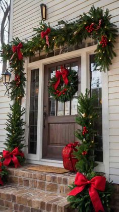 christmas wreaths on the front steps of a house