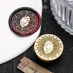 two wooden stamps sitting on top of a table next to wine glasses and a bottle opener