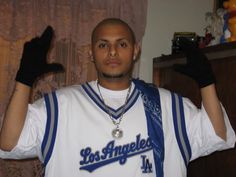 a man wearing a los angeles baseball uniform and holding his hands up in the air