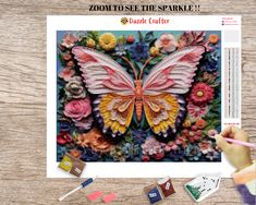 a cross stitch pattern with flowers and a butterfly in the middle on a wooden table