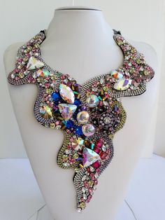 Each piece of our statement necklaces is handmade and one of a kind made in Italy. Our creations is made of high quality materials such as crystals and rhinestones. Each embroidered material is carefully hand sewn. Very glamorous and stylish. Perfect gift to someone you like. Materials Strass stone in Sapphire, Aurora Borealis, Olivine, Jonquil, Vintage Rose and Fuchsia color in different shape and dimension.  Black satin fabric backing. Aluminium chain with lobster closure. Measurements Weight approximate 200 grams. Chain lenght 20 cm - 7,87 in Necklace lenght (from the neck) 19 cm - 7,48 in Circumference of the neck 40 cm - 15,74 in Feel free to contact us if you have any question. Thank you so much for looking at our shop and our articles each of them, single piece. Multicolor Crystal Necklaces With Stones, Party Crystal Pendant Necklace With Rhinestones, Multicolor Rhinestone Necklaces For Weddings, Multicolor Rhinestone Crystal Necklace As Gift, Multicolor Crystal Necklace With Rhinestones, Unique Crystal Jewelry With Rhinestones, Multicolor Rhinestones Necklace For Wedding, Unique Rhinestone Jewelry For Gifts, Unique Rhinestone Jewelry Gift