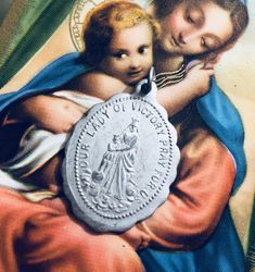 an image of the virgin mary and child jesus with a medal in its lapel