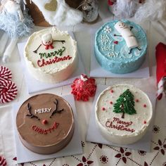 four decorated christmas cakes sitting on top of a table