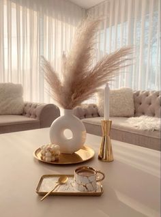 a white table topped with a vase filled with feathers