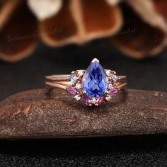 a tan gold ring with an oval shaped tan sapphire and multicolored diamond accents