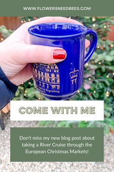 a person holding a blue coffee mug with the words, come with me don't miss my new blog post about taking a river cruise through the european christmas markets