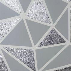 a close up view of silver glitter on a white background with squares and triangles in the middle