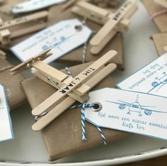 small wooden airplanes tied to brown paper on a table with tags and twine around them