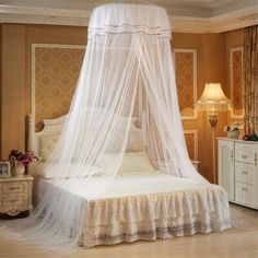 a white canopy bed in a bedroom next to a dresser