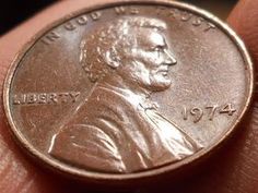 a close up of a person holding a penny in their hand with the word liberty on it