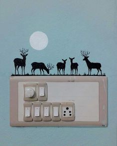 an electrical outlet cover with deer silhouettes on it and the moon in the background