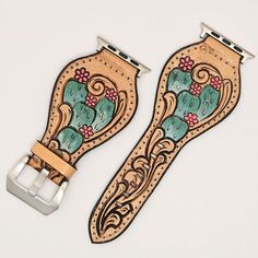 two leather watch straps with flowers and leaves on them, one has a metal buckle