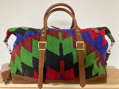 Our Handmade Bohemian Kilim Leather Travel Bag is a top pick for eco-conscious shoppers and sustainable lifestyle advocates. The roomy interior and durable construction make it a reliable choice for weekend getaways and outdoor adventures, while the multicolor woven design and leather accents make it a stylish accessory for fashion-conscious nomads and rustic explorers.Looking for a versatile statement piece? Our Handmade Vintage Kilim Leather Multicolor Bag is the perfect pick for creative indi Luxury Multicolor Shoulder Bag For Travel, Green Weekender Bag With Leather Handles For Travel, Luxury Leather Trim Bags For Vacation, Multicolor Rectangular Bag With Leather Trim, Brown Leather Trim Shoulder Bag For Vacation, Luxury Multicolor Satchel For Travel, Rectangular Woven Satchel For Travel, Woven Rectangular Satchel For Travel, Woven Travel Tote Satchel