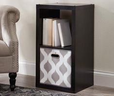 a black bookcase with two bins next to a chair