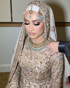 a woman in a bridal outfit with jewelry on her head