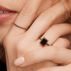 a close up of a person with a ring on their finger and her hand near her face