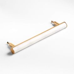 a white and gold toilet roll holder with two brass handles on the top, one in the shape of a tube