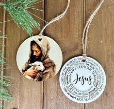 a christmas ornament hanging from a pine tree with the word jesus printed on it