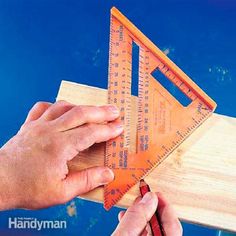 a person using a ruler to measure the height of a piece of wood with their hands