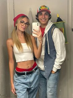 a man and woman are taking a selfie in the bathroom together, one is holding a cell phone