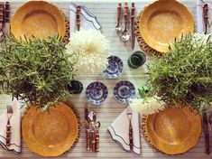 the table is set with plates, silverware and flowers