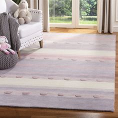 a white couch sitting next to a window on top of a hard wood floor covered in furniture