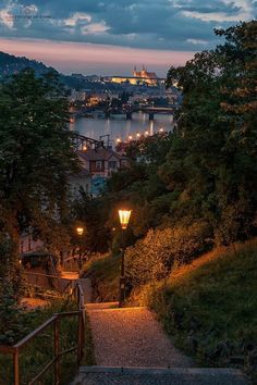 the stairs lead up to the top of the hill at night with lights shining on them